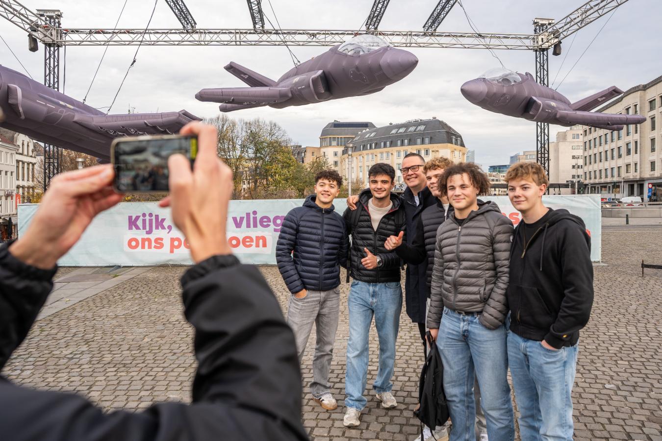 Une photo de groupe où des jeunes posent avec Raoul Hedebouw