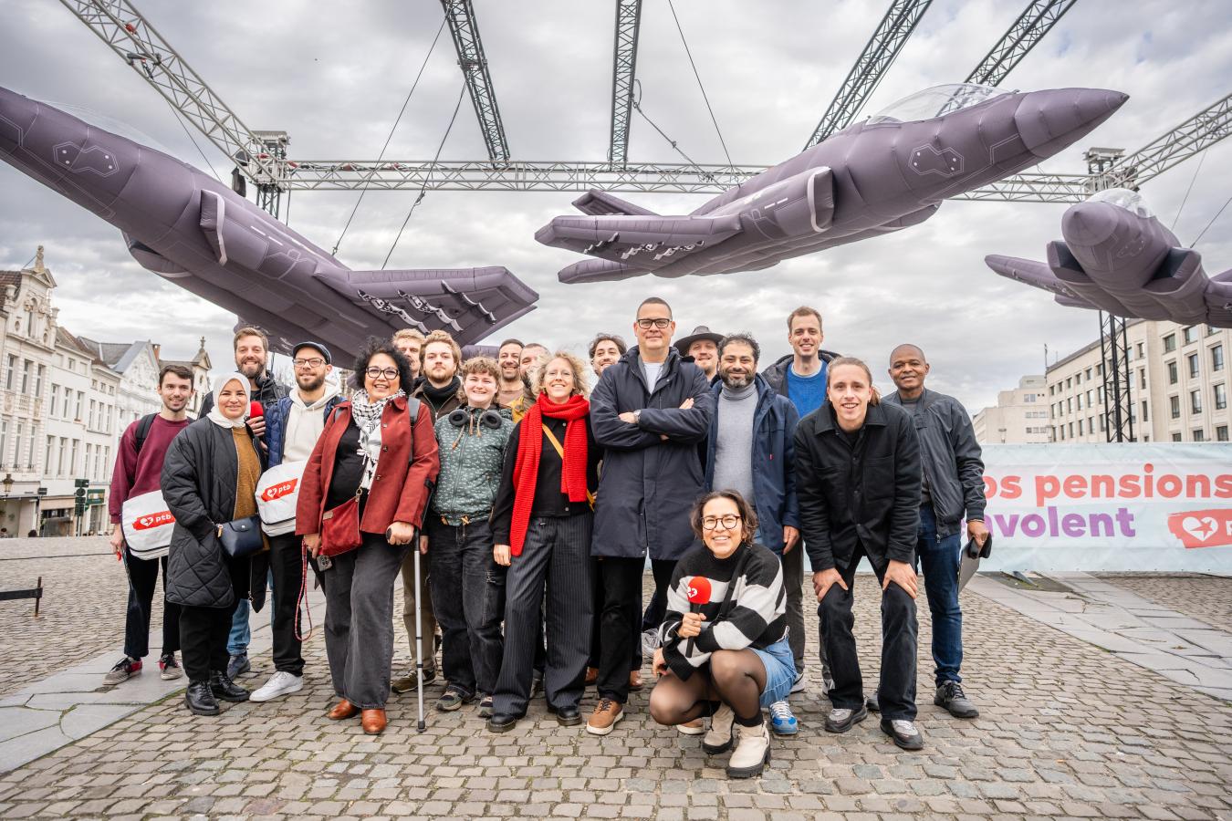Une photo de groupe sous les trois F-35 gonflables. Raoul Hedebouw est au centre.